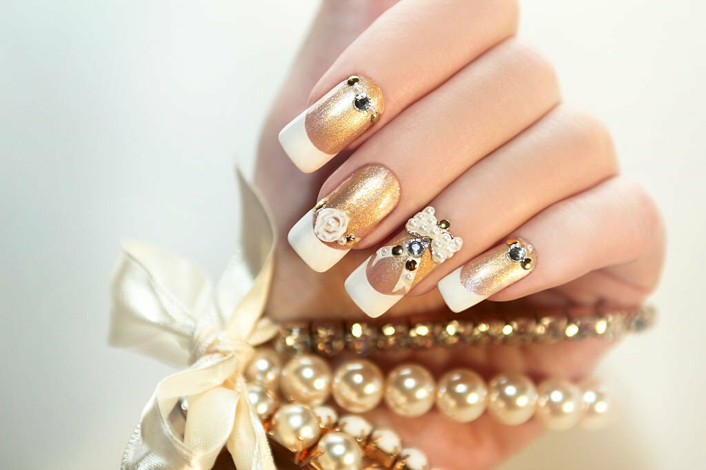 Pearl French manicure with rhinestones and embellishments.